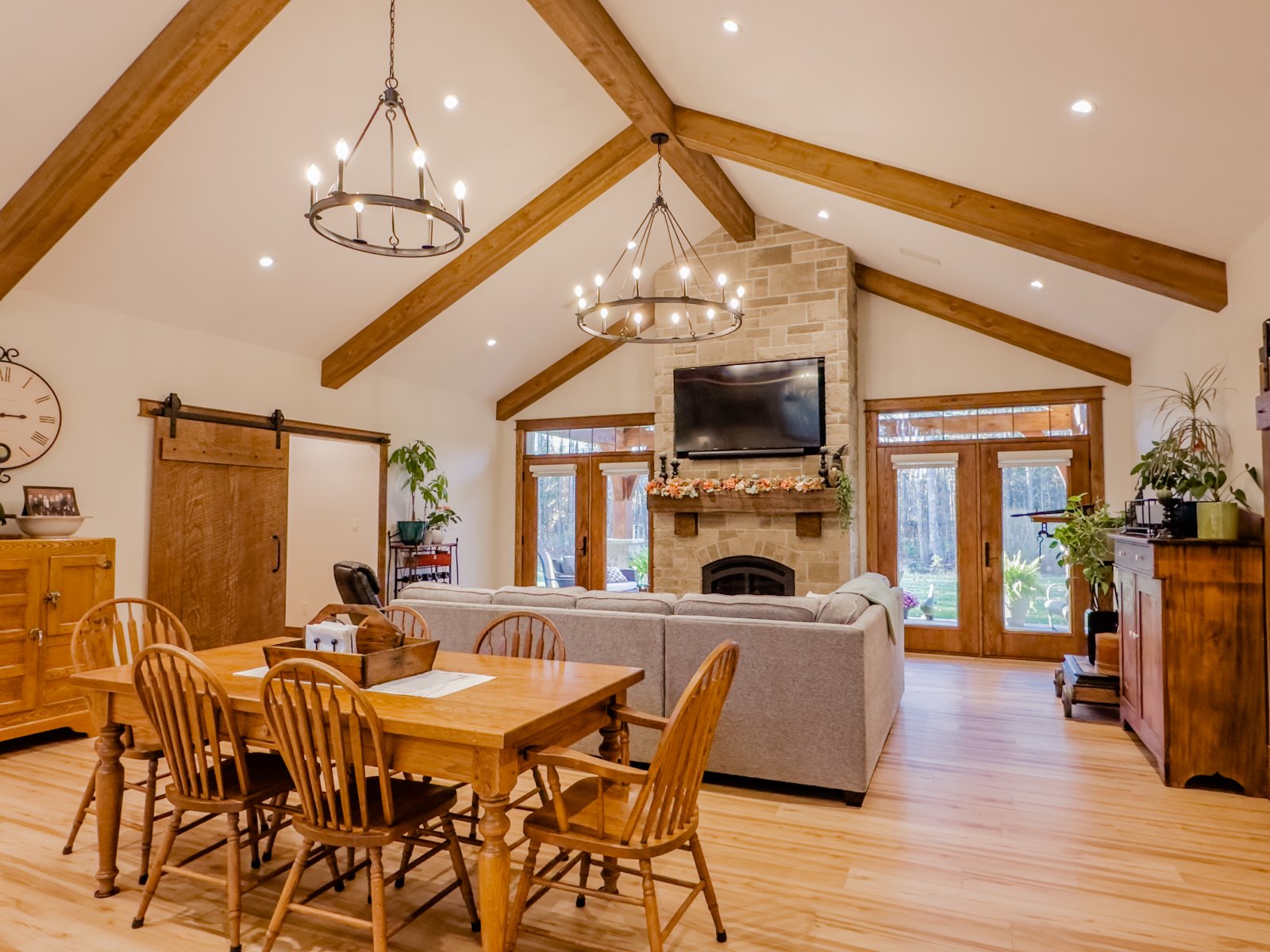 Great room with vaulted ceiling, timber beams and a stone fireplace