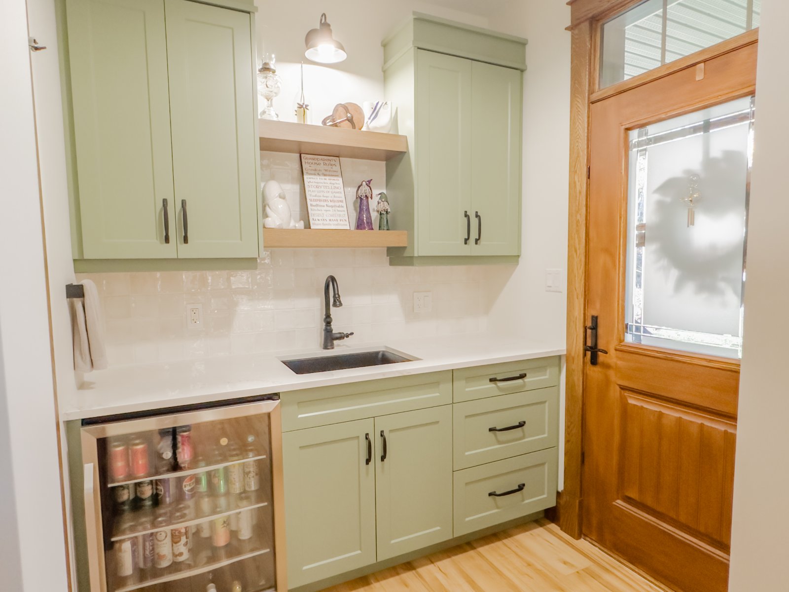Butler's pantry with sage cabinetry and beverage fridge