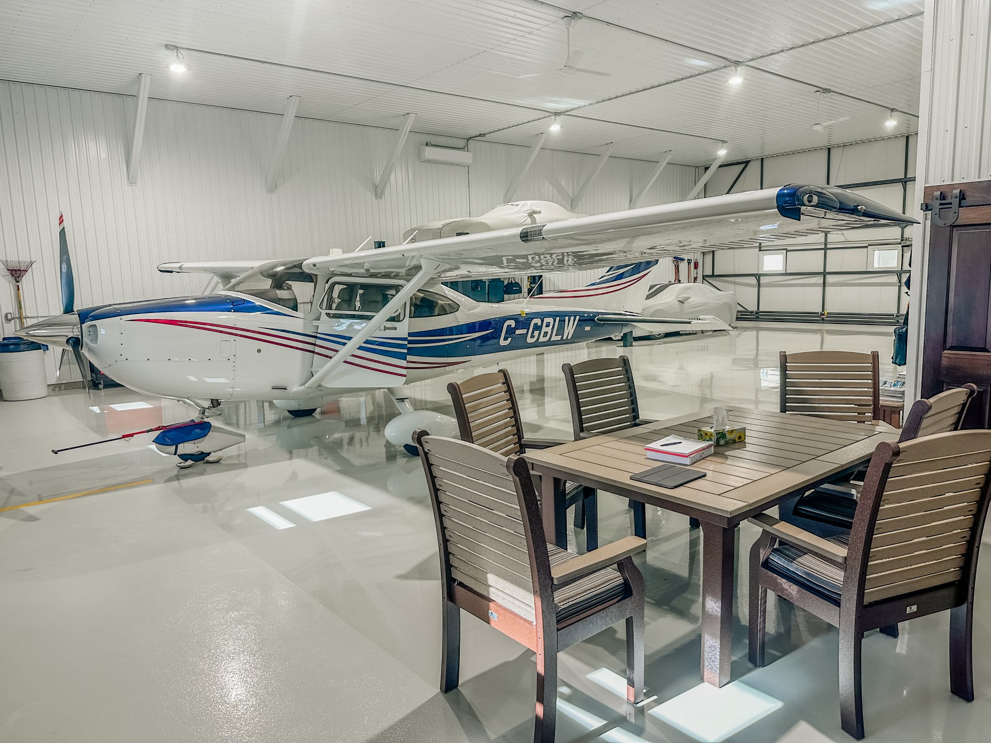 Lang's General Contracting — private aircraft hangar housing a Cessna on a finished epoxy floor, Ontario