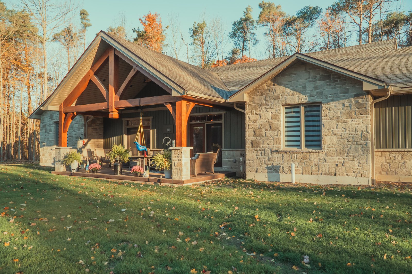 Lang's General Contracting — custom timber-frame and stone home exterior at golden hour